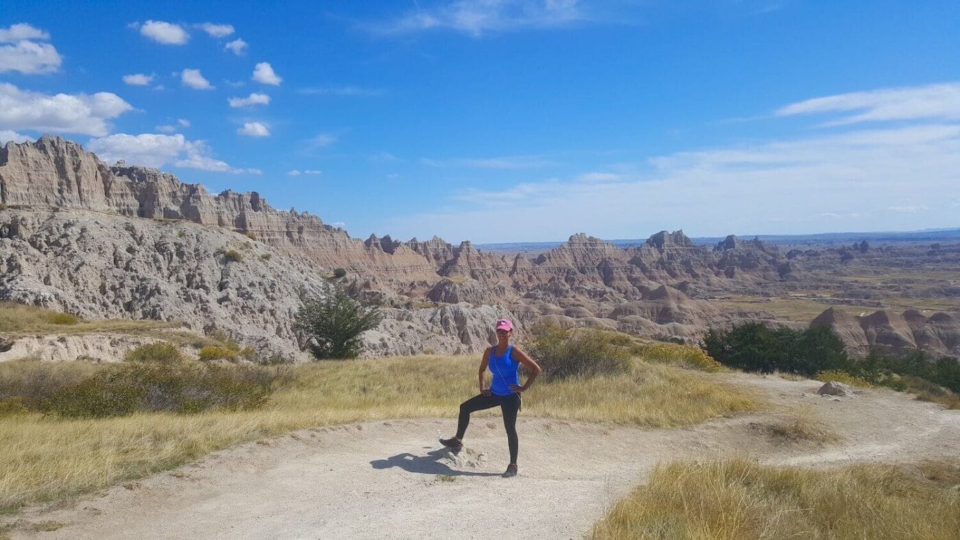 black outdoorsy woman posing on a hiking trail in the badlands